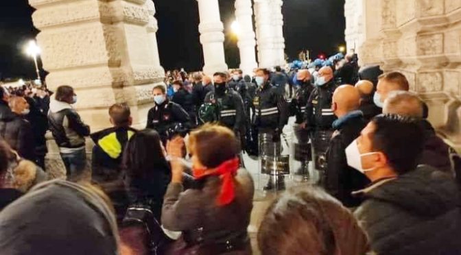 Trieste, 26 ottobre 2020 (non un anniversario a caso per il capoluogo giuliano). Il cuore della piazza si ferma per un attimo: la Polizia si toglie il casco per rispetto ai cittadini.